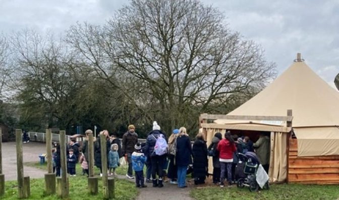 Families queuing outside canopy classroom